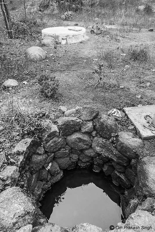 Optimizing traditional drinking water sources for accelerating change - A view of the 'chua' (spring-based water source), showing the new spring-based sanitary well in the background in Paharia Tola, village Jhajhapara, district Dumka, Jharkhand